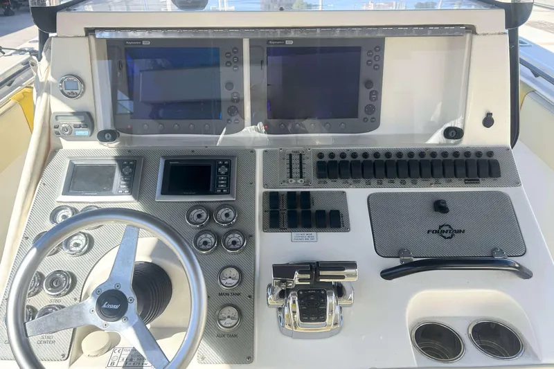 4play Yacht Photos Pics Control panel of 2013 Fountain 38 Sportfish CC Open Bow boat with steering wheel and displays.