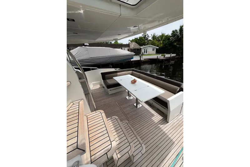 Bugsy Yacht Photos Pics Outdoor seating area on 2020 Galeon 550 Fly yacht with wooden deck and table.