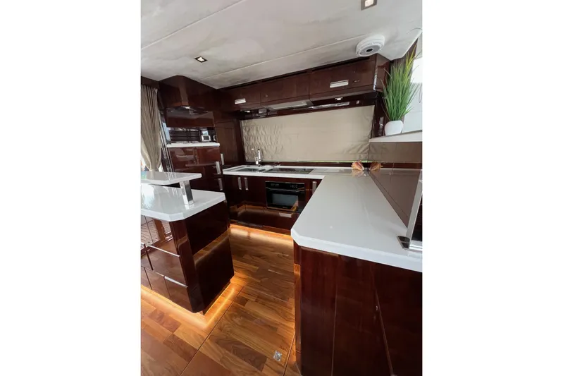 Bugsy Yacht Photos Pics Luxurious kitchen interior of 2020 Galeon 550 Fly yacht with modern design and wood finishes.