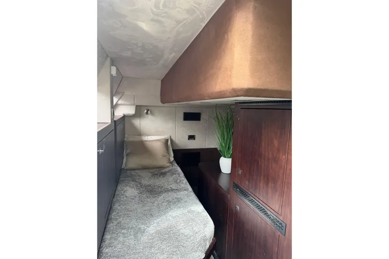 Bugsy Yacht Photos Pics Cozy cabin interior of 2020 Galeon 550 Fly yacht with bed and wooden cabinetry.