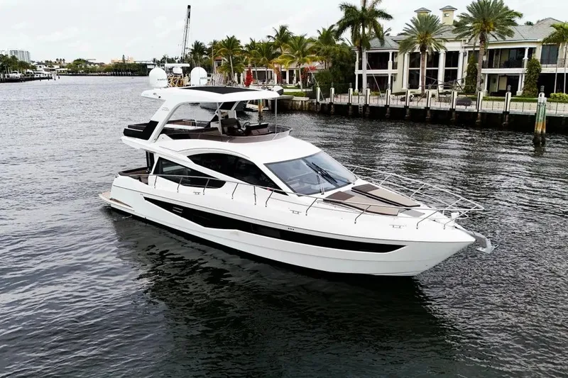 Bugsy Yacht Photos Pics 2020 Galeon 550 Fly yacht cruising near waterfront homes with palm trees.
