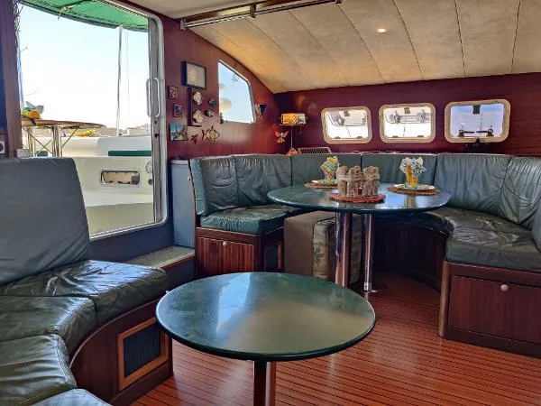  Yacht Photos Pics Interior of 1997 Fountaine Pajot Marquises 56 yacht with cozy seating and wooden decor.