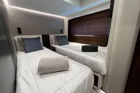 2023 Astondoa AS8 yacht bedroom with twin beds, modern decor, and ambient lighting.