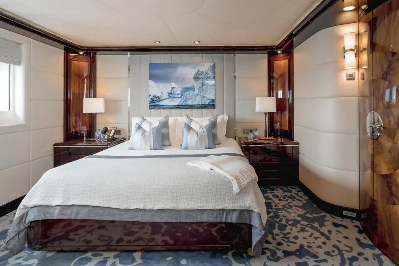 Dream Yacht Photos Pics Luxurious yacht bedroom with elegant decor, featuring a large bed, modern lighting, and stylish artwork.