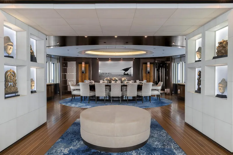 Dream Yacht Photos Pics Luxurious yacht dining room with elegant decor, featuring a round table and artistic displays.