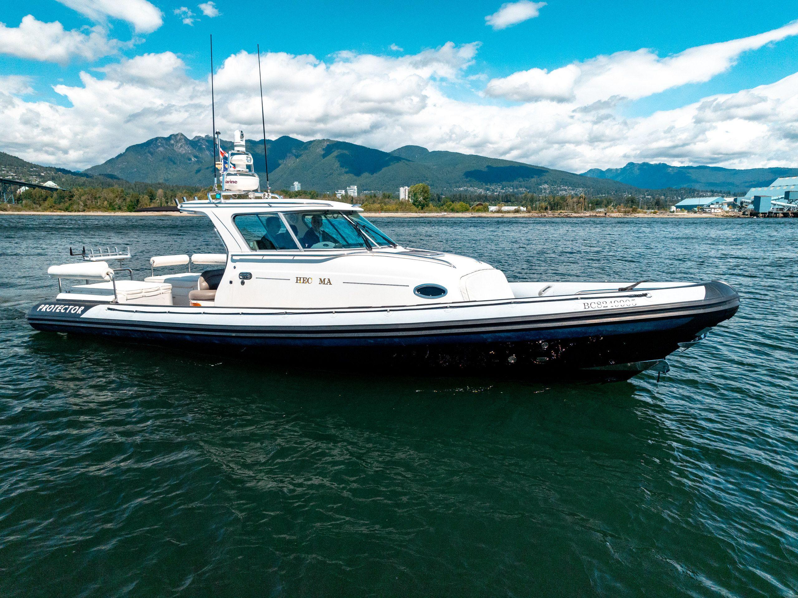 2009 Protector Targa 35 boat on water with mountains in background.