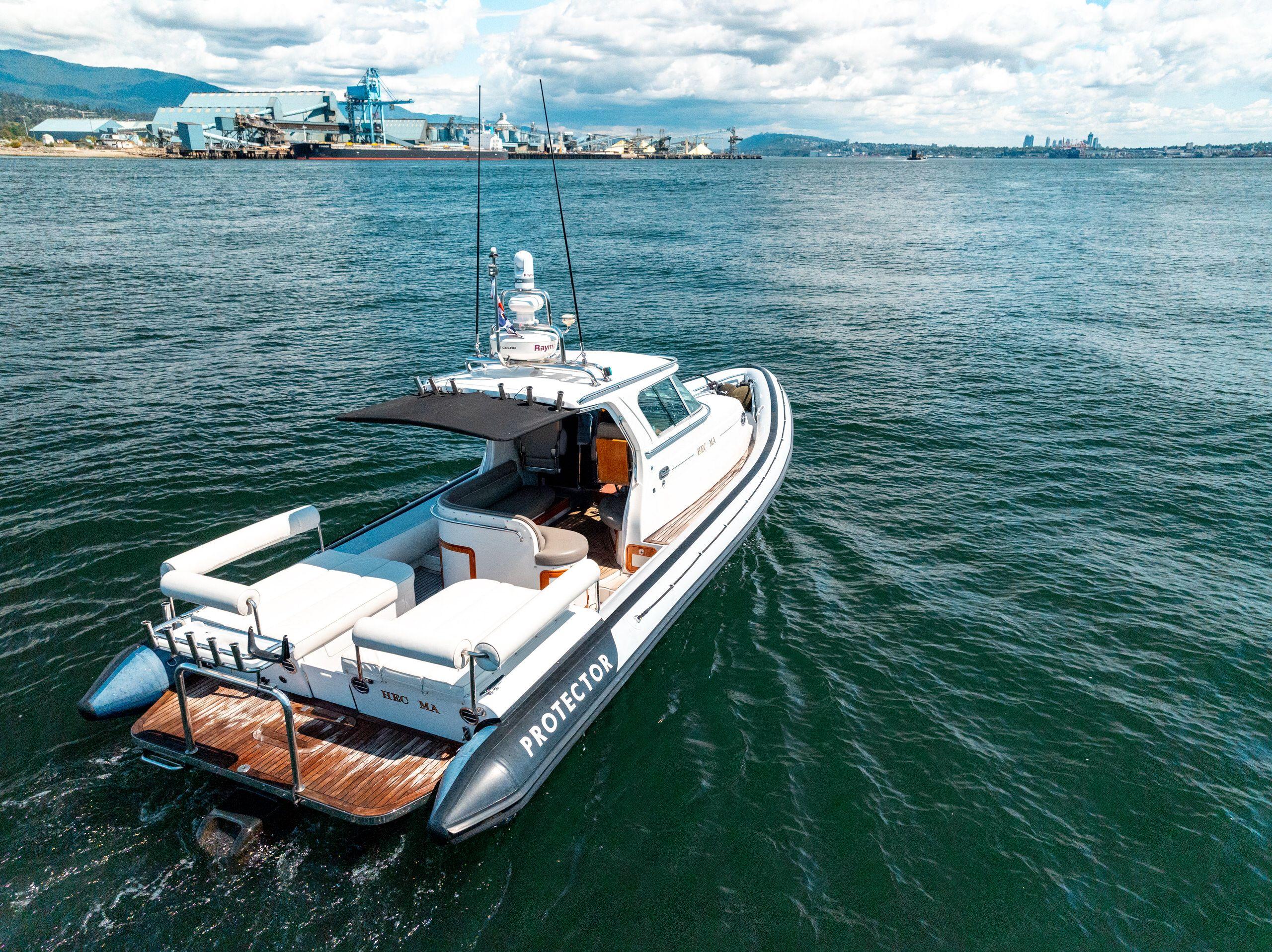 2009 Protector Targa 35 boat on open water, clear sky, industrial background.