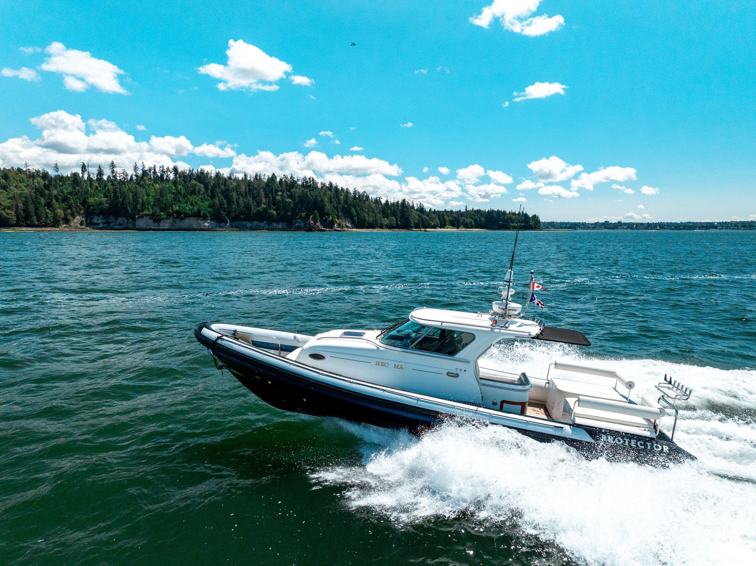 2009 Protector Targa 35 boat cruising on a sunny day, surrounded by scenic water and trees.