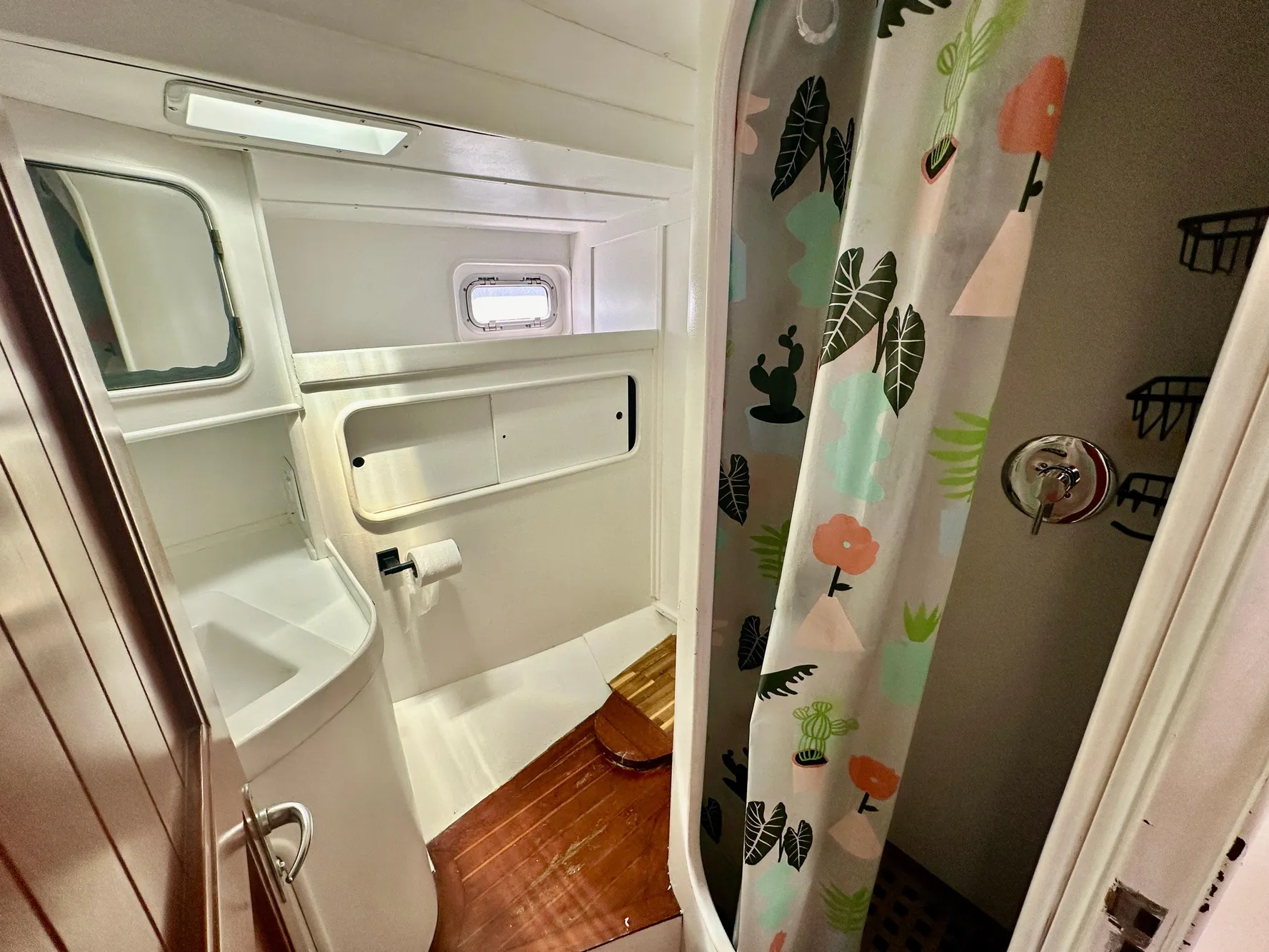 Bathroom interior of 1983 Tayana 55 yacht with shower and wooden flooring.