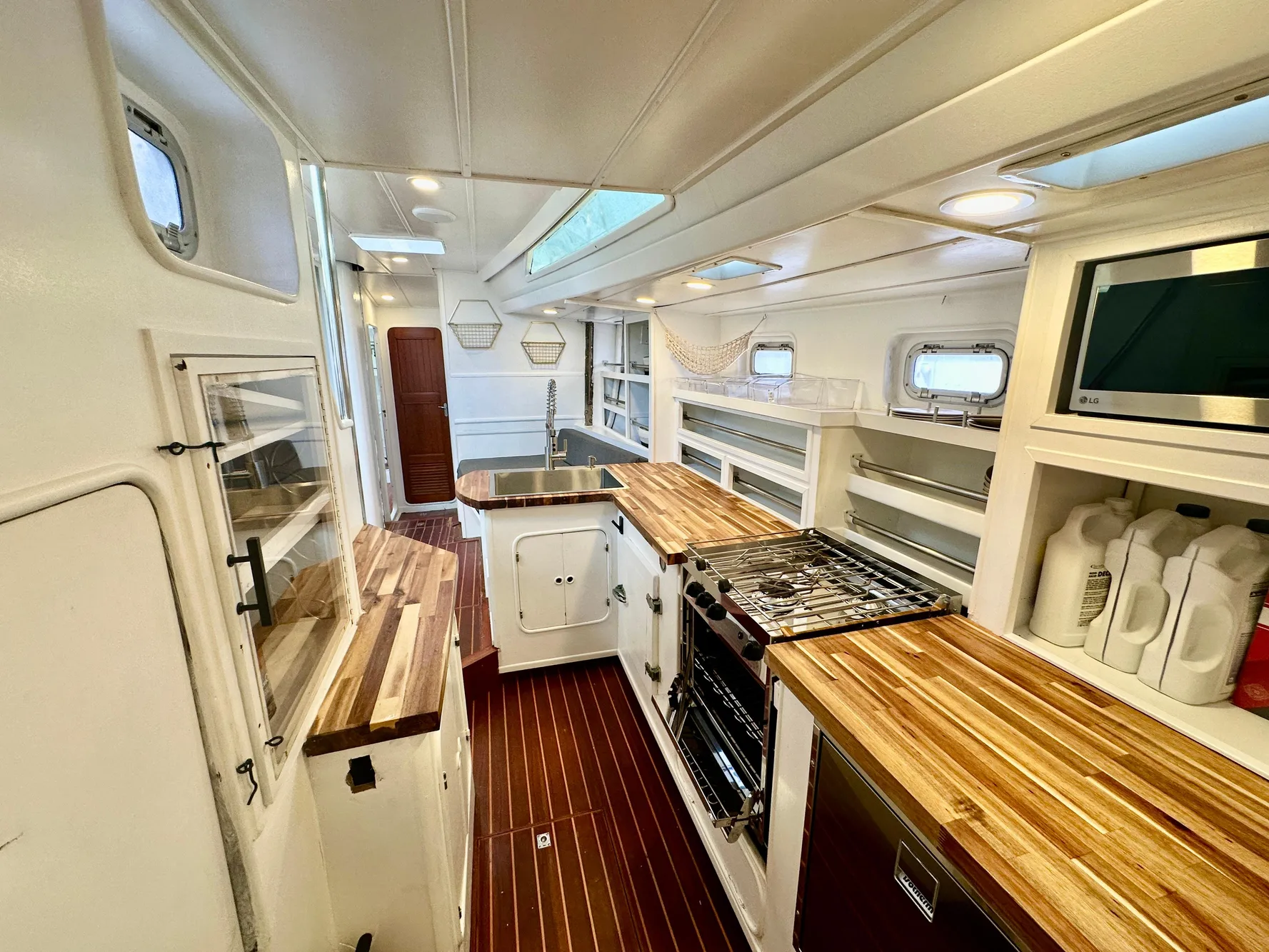 Spacious 1983 Tayana 55 yacht interior with modern kitchen and wooden countertops.