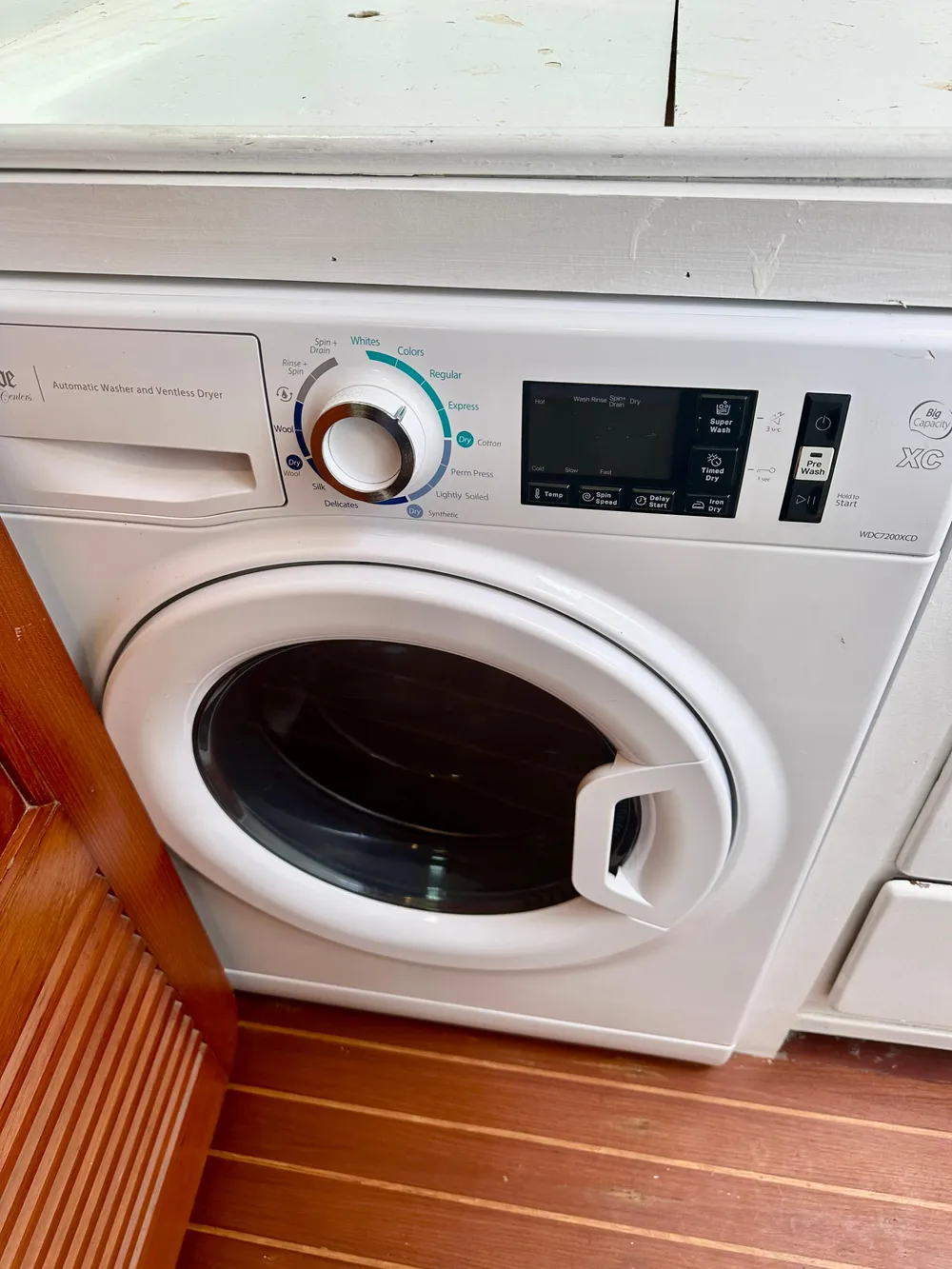 Washing machine on a Tayana 55 yacht, 1983 model, with wooden flooring.