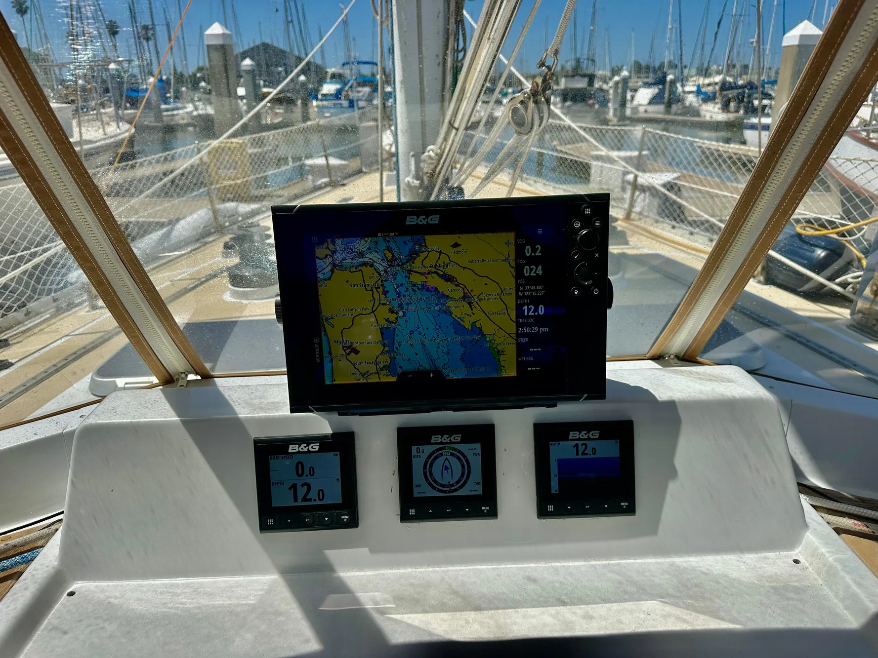 Cockpit of 1983 Tayana 55 sailboat with navigation instruments and marina view.