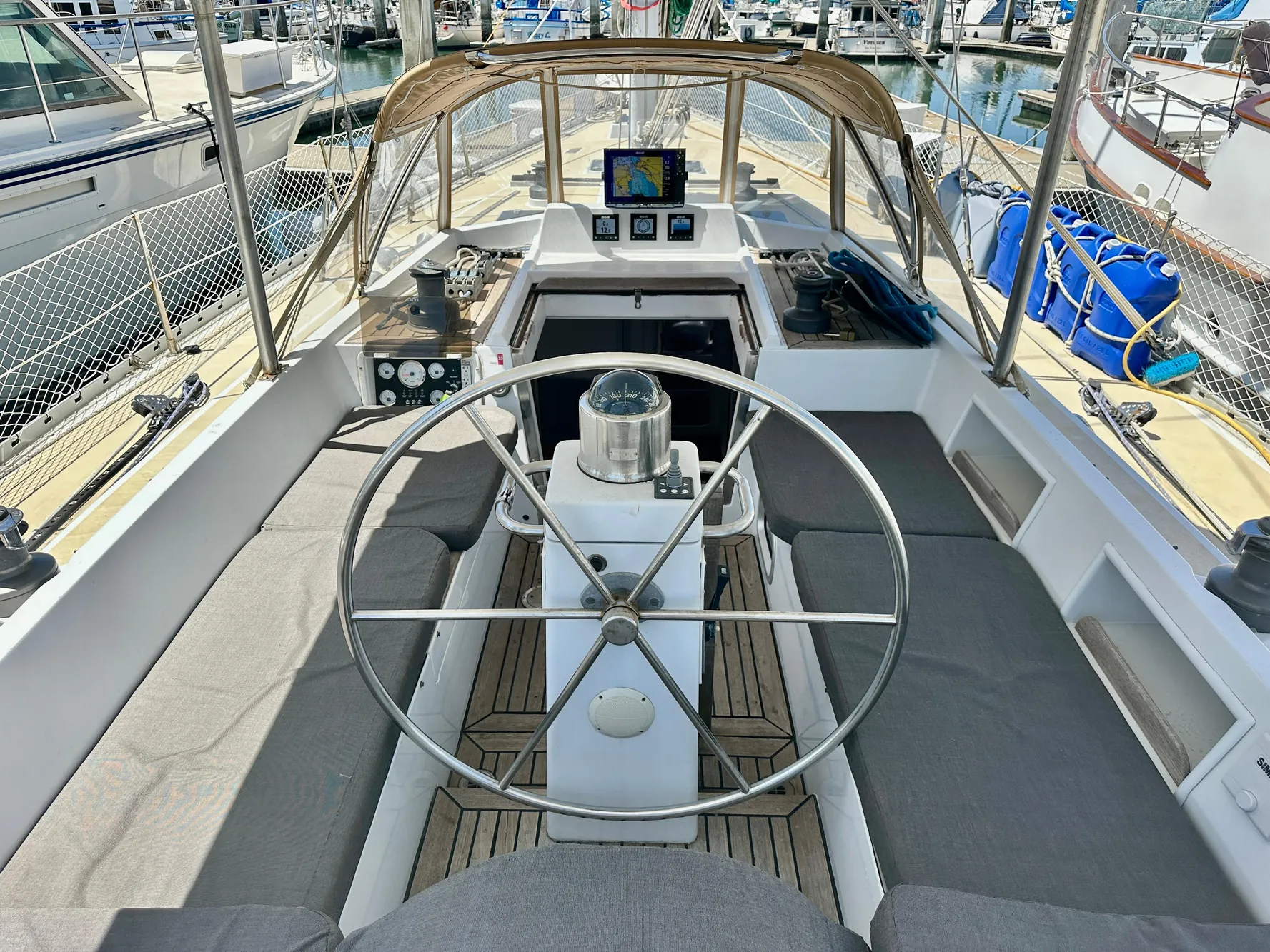 Cockpit of 1983 Tayana 55 sailboat with steering wheel and navigation equipment.