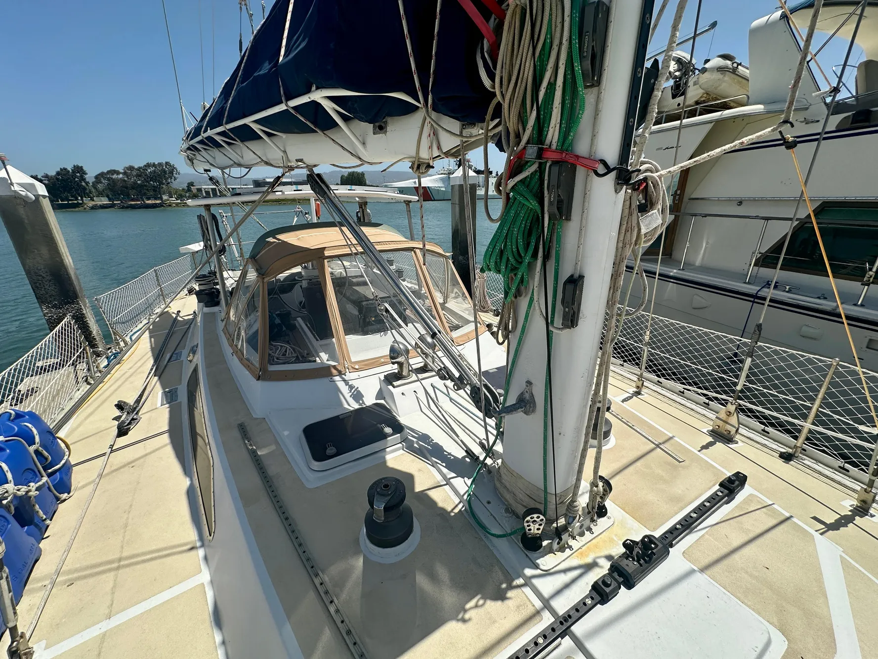 Sailboat deck view of 1983 Tayana 55, docked with clear skies and calm waters.
