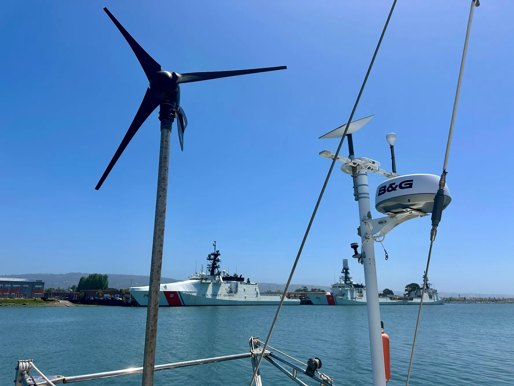 Sailboat with wind turbine and radar, Tayana 55, 1983, near coast guard ships.