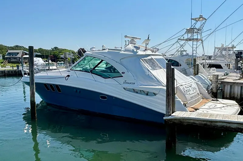 Knee Deep Yacht Photos Pics 2006 Sea Ray 48 Sundancer yacht docked in a marina under clear blue skies.