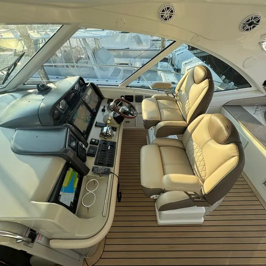 Knee Deep Yacht Photos Pics Luxurious helm of 2006 Sea Ray 48 Sundancer with dual leather seats and advanced navigation systems.