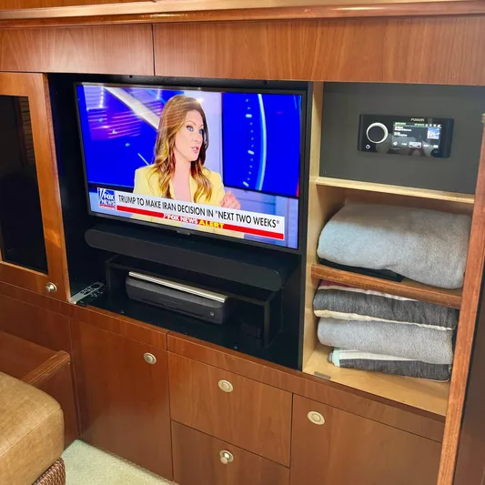 Knee Deep Yacht Photos Pics Entertainment area inside 2006 Sea Ray 48 Sundancer yacht with TV and storage shelves.