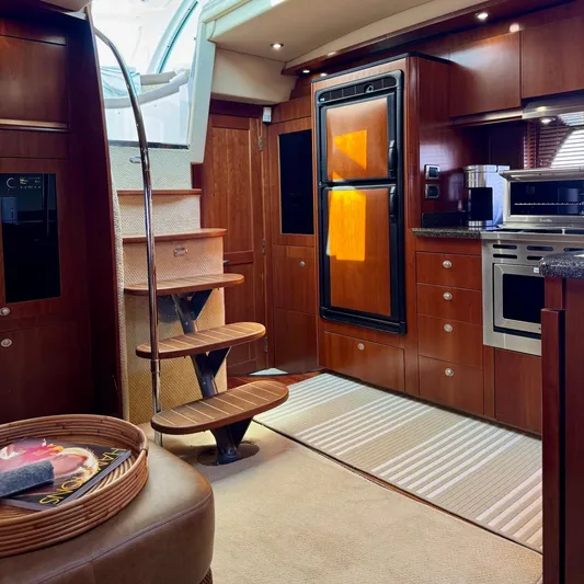 Knee Deep Yacht Photos Pics Luxurious interior of 2006 Sea Ray 48 Sundancer yacht with wooden cabinetry and modern appliances.