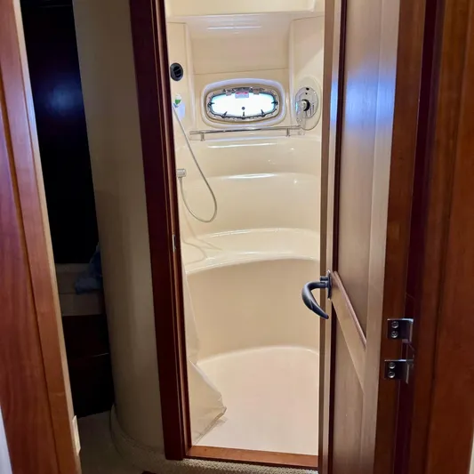 Knee Deep Yacht Photos Pics Shower area inside 2006 Sea Ray 48 Sundancer yacht, featuring a compact design and porthole window.