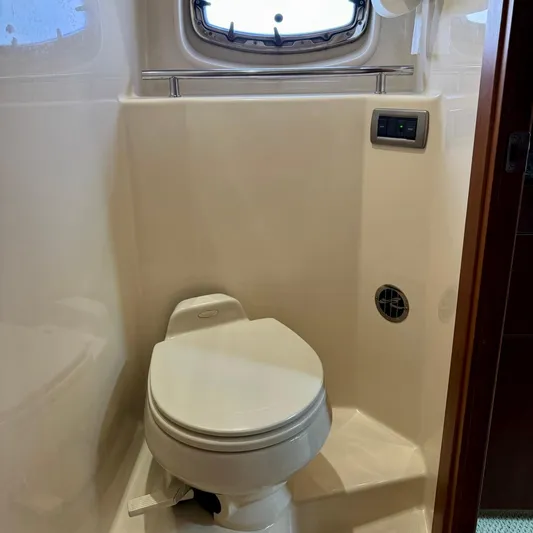 Knee Deep Yacht Photos Pics Bathroom interior of 2006 Sea Ray 48 Sundancer yacht with toilet and porthole.