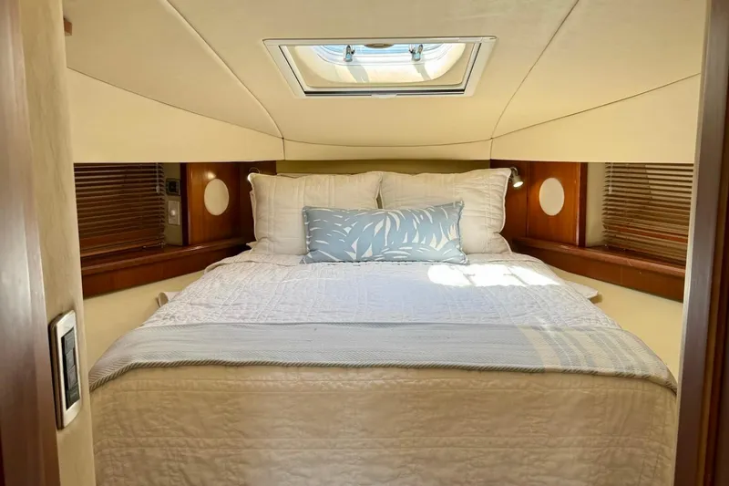 Knee Deep Yacht Photos Pics Luxurious cabin interior of 2006 Sea Ray 48 Sundancer yacht with skylight and cozy bedding.