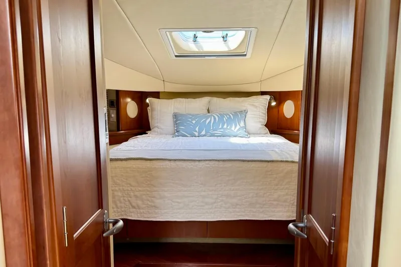 Knee Deep Yacht Photos Pics Luxurious cabin interior of 2006 Sea Ray 48 Sundancer yacht with skylight and cozy bedding.