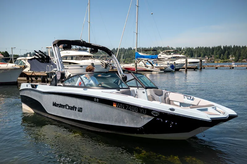  Yacht Photos Pics 2022 MasterCraft XT24 boat on a sunny day at a marina.