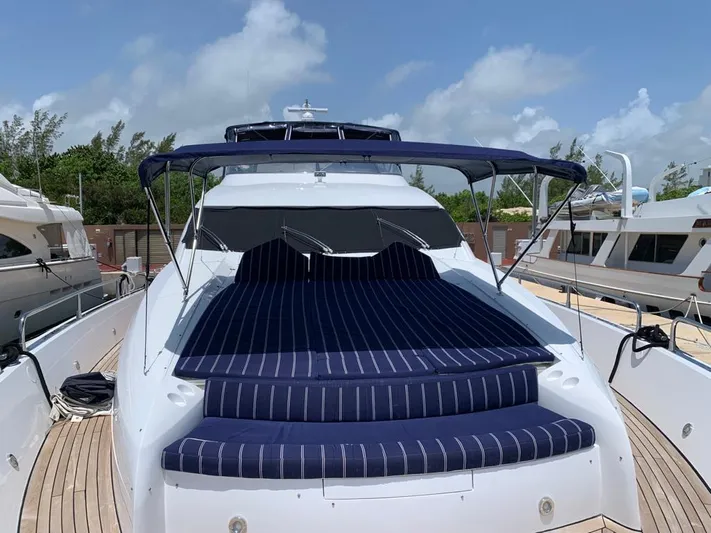 Julcan II Yacht Photos Pics 2006 Sunseeker 90 Yacht with striped sunbed, docked under a clear sky.