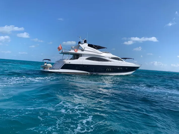 Julcan II Yacht Photos Pics 2006 Sunseeker 90 Yacht cruising on clear blue ocean under a sunny sky.