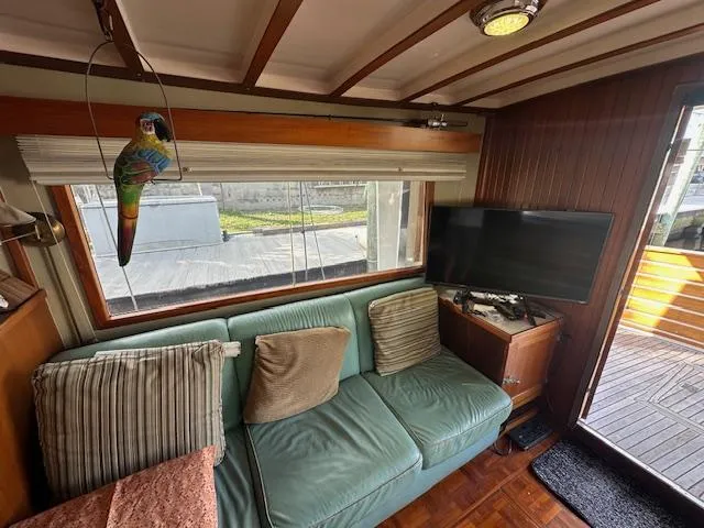 Tortuga Yacht Photos Pics Cozy interior of 1987 Kadey-Krogen 42 boat with sofa, TV, and decorative parrot.