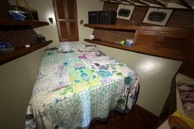 Tortuga Yacht Photos Pics Cozy cabin bedroom in 1987 Kadey-Krogen 42 boat with floral quilt and wooden shelves.