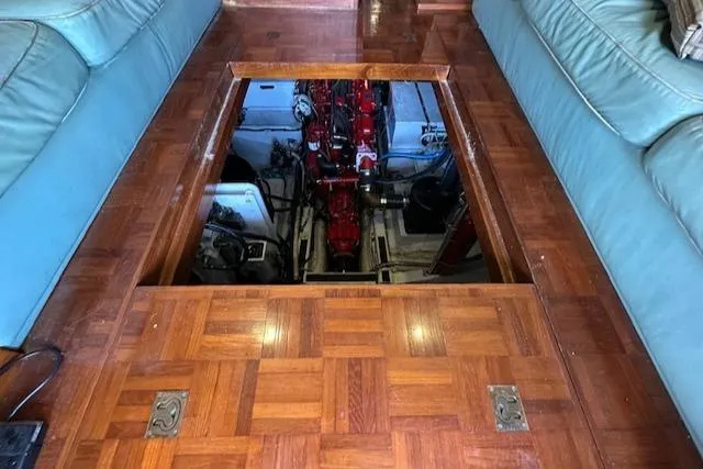 Tortuga Yacht Photos Pics Engine compartment of 1987 Kadey-Krogen 42 yacht with wooden flooring and blue seating.