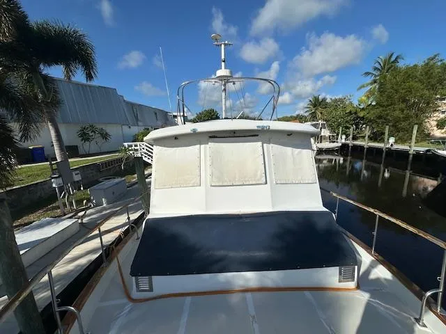 Tortuga Yacht Photos Pics 1987 Kadey-Krogen 42 yacht docked by a canal under a clear blue sky.