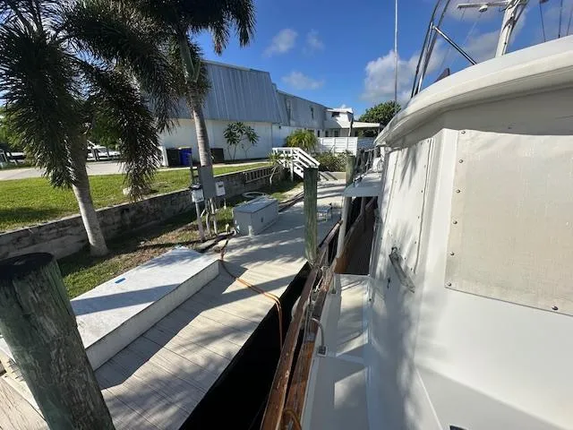Tortuga Yacht Photos Pics 1987 Kadey-Krogen 42 yacht docked beside a wooden pier, surrounded by tropical greenery.