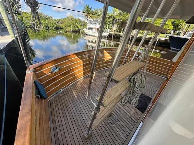 Tortuga Yacht Photos Pics 1987 Kadey-Krogen 42 boat deck with wooden flooring and metal railings, docked by a serene waterway.