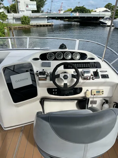  Yacht Photos Pics 2004 Meridian 381 yacht helm with Garmin navigation, docked by a scenic waterfront.