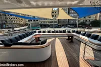 Luxurious 2024 Custom 29m Charter MY yacht deck with seating, tables, and sunshades.