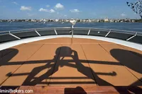 Front deck of 2024 Custom 29m Charter MY yacht with cityscape in background.