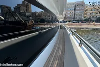 Side deck view of 2024 Custom 29m Charter MY yacht docked near urban waterfront.