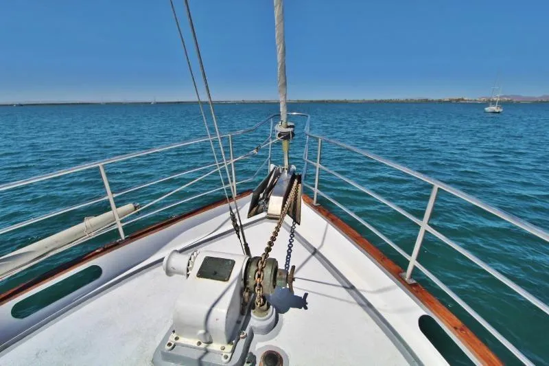 Centre cockpit pilot house steel cutter motorsailer on calm blue waters, 1991 model.