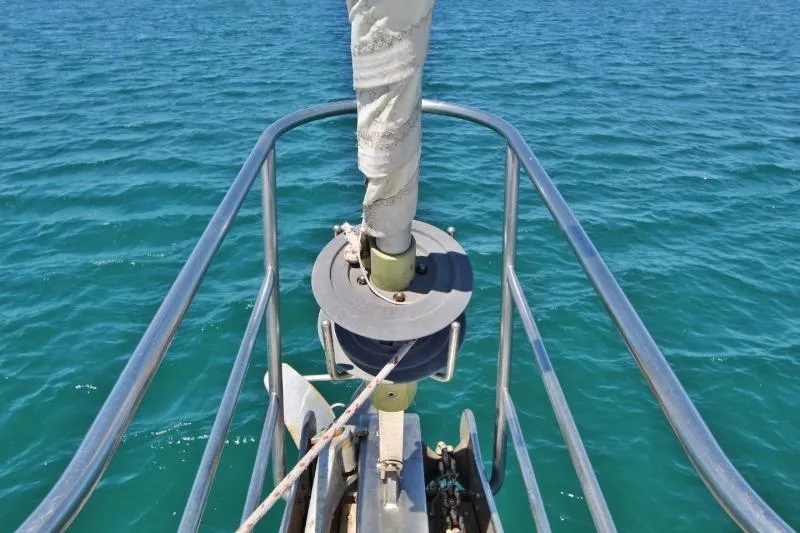 Ocean Villa Yacht Photos Pics Bow of 1991 Custom Centre Cockpit Pilot House Steel Cutter Motorsailer on blue ocean.