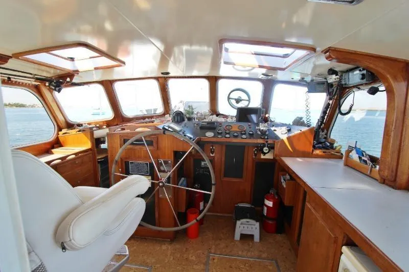 Ocean Villa Yacht Photos Pics Centre cockpit of a 1991 custom steel cutter motorsailer with wooden interior and navigation equipment.
