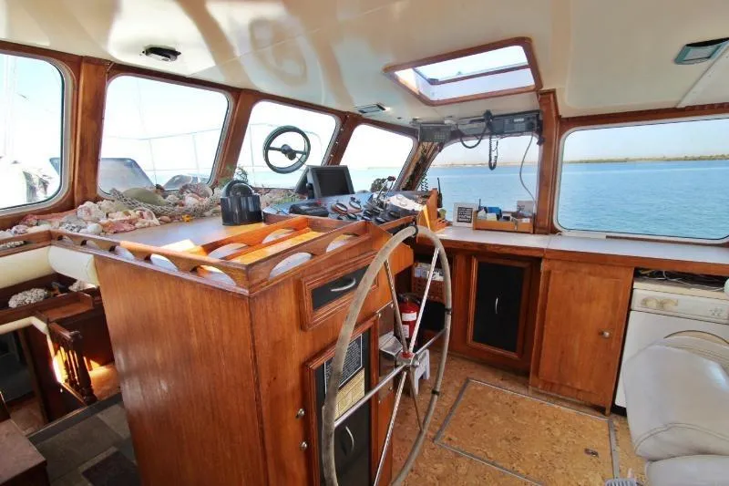 Ocean Villa Yacht Photos Pics Centre cockpit pilot house of a 1991 steel cutter motorsailer with wooden interior and navigation equipment.