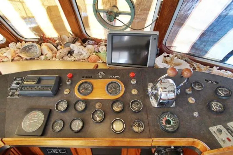 Ocean Villa Yacht Photos Pics Centre cockpit of 1991 Custom Motorsailer with gauges, controls, and decorative seashells.