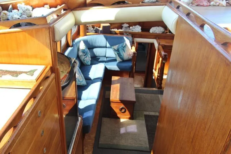 Ocean Villa Yacht Photos Pics Interior of 1991 Custom Centre Cockpit Pilot House Motorsailer with blue seating and wooden finishes.
