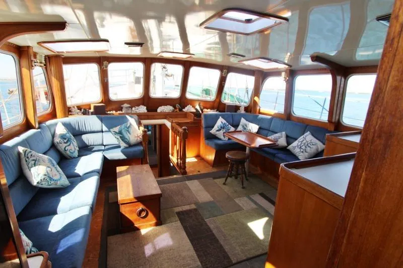 Ocean Villa Yacht Photos Pics Luxurious interior of a 1991 Custom Centre Cockpit Pilot House Motorsailer with blue seating.