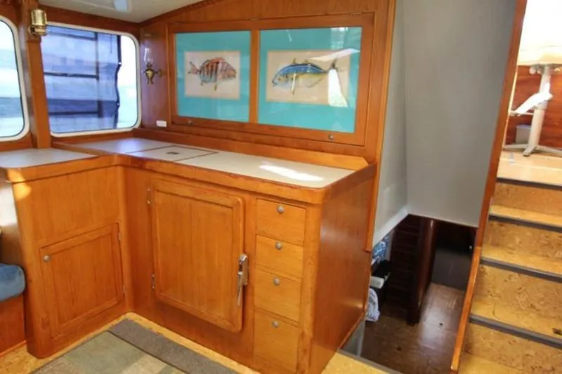 Ocean Villa Yacht Photos Pics Interior of 1991 Custom Motorsailer with wooden cabinetry and nautical artwork.