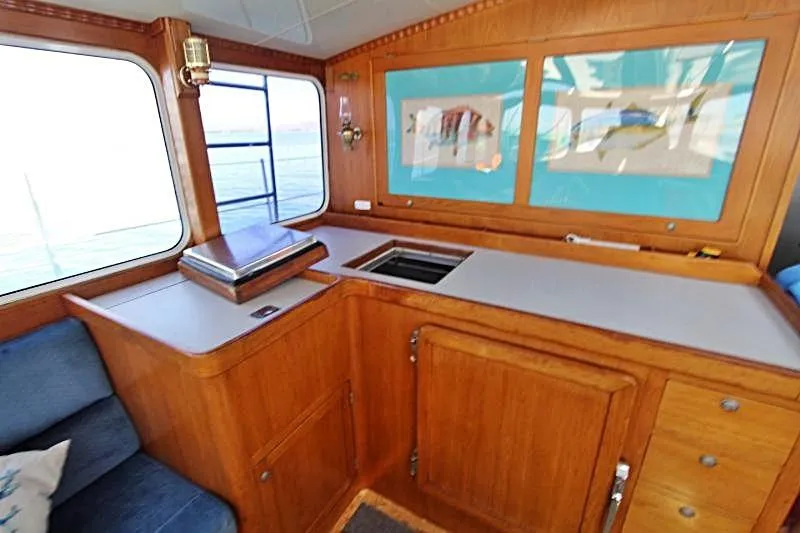 Ocean Villa Yacht Photos Pics Interior of 1991 Custom Centre Cockpit Pilot House Motorsailer with wooden cabinetry and ocean view.
