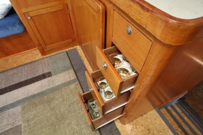 Ocean Villa Yacht Photos Pics Wooden drawers in a 1991 Custom Centre Cockpit Pilot House Motorsailer, storing glassware.